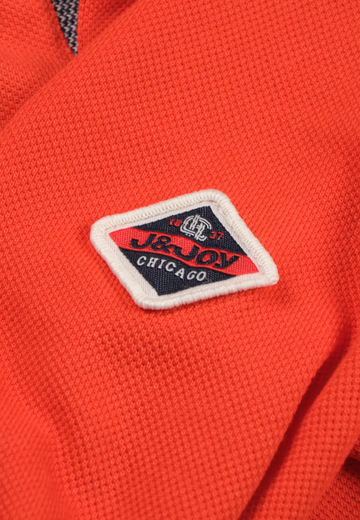 Polo garon orange avec motif arrière